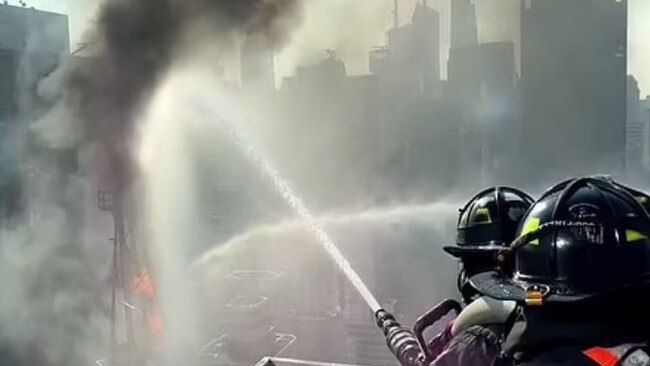 Firefighters fight a blaze that began in the cab of a crane in New York. Picture: Supplied