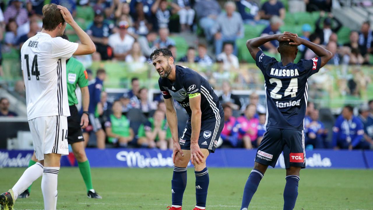 Alex Rufer of Wellington Phoenix, Elvis Kamsoba and Carl Valeri of Melbourne Victory react. (AAP Image/George Salpigtidis) 