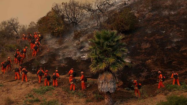 Inmate firefighters dig a containment line as they battle the Palisades Fire. Picture: AFP