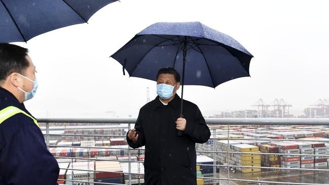 Stormy skies: Chinese President Xi Jinping tries out the latest coronavirus shield. Picture: AP