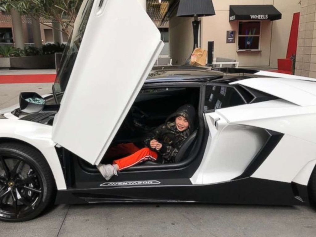 Lil Tay in a sports car with "butterfly" wings.