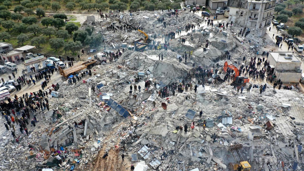 TOPSHOT - This aerial view shows residents searching for victims and survivors amidst the rubble of collapsed buildings following an earthquake in the village of Besnia near the twon of Harim, in Syria's rebel-held noryhwestern Idlib province on the border with Turkey, on February 6, 2022. - Hundreds have been reportedly killed in north Syria after a 7.8-magnitude earthquake that originated in Turkey and was felt across neighbouring countries. (Photo by Omar HAJ KADOUR / AFP)