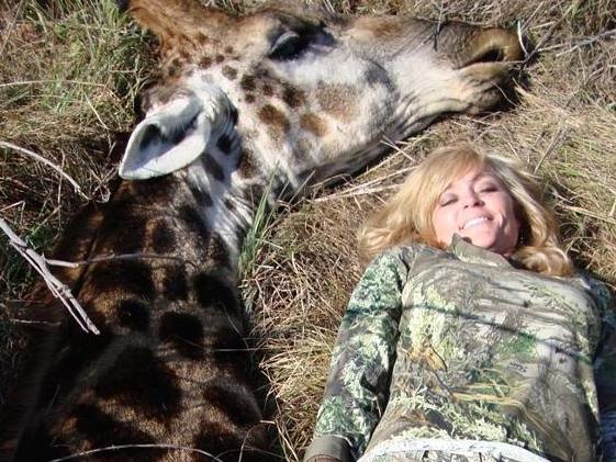 US hunter Rebecca Francis poses smiling next to a giraffe she had just killed during a safari tri