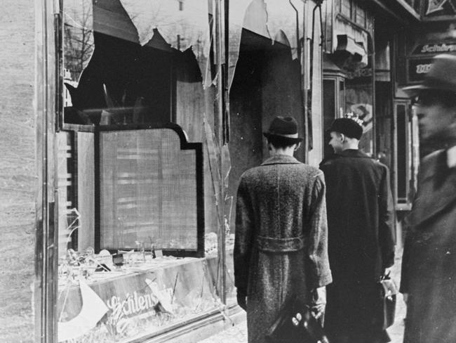 Germans pass by the broken shop window of a Jewish-owned business destroyed during Kristallnacht in Berlin. Picture: Supplied