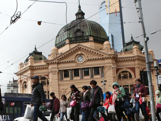 Pedestrians are are seen in wild weather outside Flinders Street Station in Melbourne, Sunday, June 17. 2018. (AAP Image/David Crosling) NO ARCHIVING