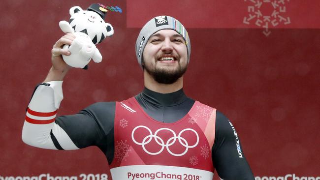 David Gleirscher of Austria smiles with a toy tiger after taking the bronze medal during the winner's ceremony of the men's luge competition. Picture: Andy Wong/AP