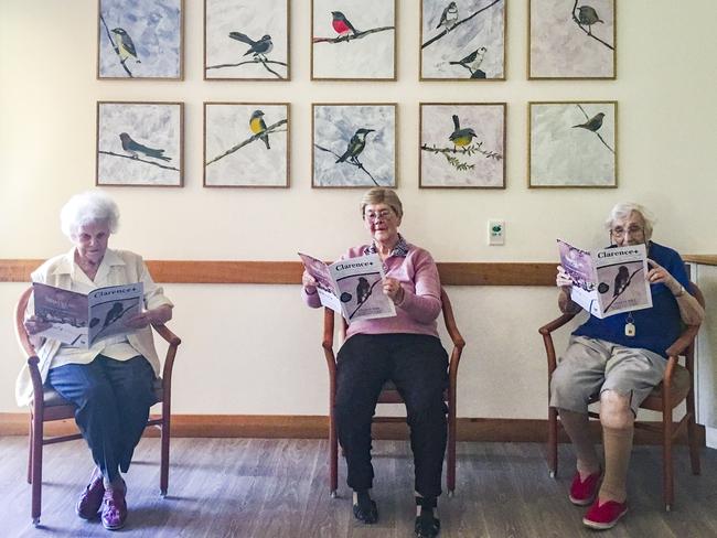 Socially distanced residents of Dougherty Villa read the final edition of The Daily Examiner’s Clarence+ magazine in April, in front of the Little Birds of the Clarence Valley artworks by Robert Moore which were produced for the Waratah Wing extension and featured on the cover of the magazine.