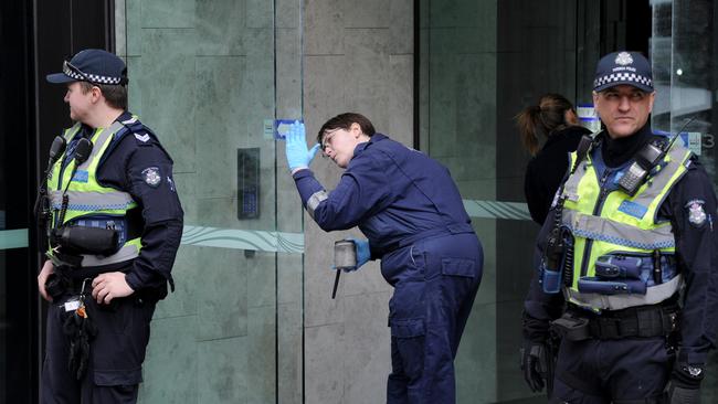 Forensic police examine the entrance to EQ Tower. Picture: Andrew Henshaw