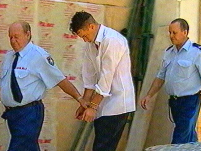 Nicholas Grayson being walked to court by police in Sydney in 2001.