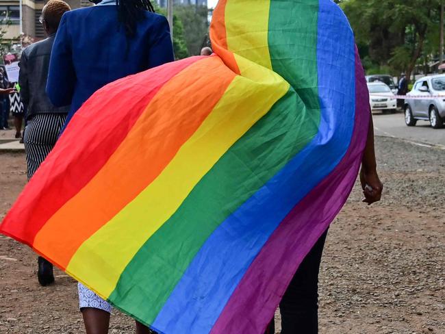 (FILES) In this file photo taken on May 24, 2019 An LGBTQ community member wearing a rainbow flag leaves the Milimani high court in Nairobi, Kenya, after the verdict on scrapping laws criminalising homosexuality. - Kenya, like its neighbours, is in the grip of a brutal cost of living crisis and faces its worst drought in four decades.  But those issues have been pushed to the back-burner as leaders across the political spectrum unite to unleash a campaign of "state-sponsored homophobia", activists say.  Homosexuality is illegal in many East African countries, which have a history of repression and stigma, encouraged by Muslim and Christian religious conservatives. In Kenya and Tanzania gay sex remains a crime under colonial-era laws with penalties including prison terms of up to 14 years.  Convictions are rare, and despite the legal issues surrounding homosexuality, gay rights groups have been allowed to operate in Kenya, unlike in neighbouring nations such as Somalia. But the law has made the LGBTQ community in Kenya easy prey for police harassment and online attacks.  And conditions have worsened since the most recent wave of homophobia took hold. (Photo by TONY KARUMBA / AFP)