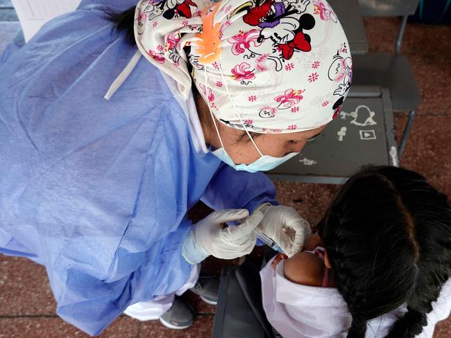 A health worker inoculates a child against COVID-19 with a Covid vaccine, developed by China's Sinovac firm, at a school in Quito on October 18, 2021. Picture: RODRIGO BUENDIA / AFP.