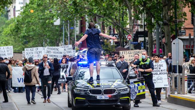 A protester jumps on top of a police highway patrol car. Picture: NCA NewsWire/Sarah Matray