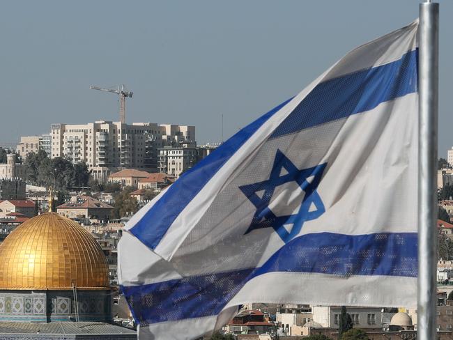 The Israeli flag flutters in front of the Dome of the Rock mosque and th city of Jerusalem, on December 1, 2017.  Two Israeli cabinet ministers said on November 30 that they hoped US President Donald Trump was about to move his country's embassy from Tel Aviv to Jerusalem, as a decision deadline neared. The issue is deeply controversial. Shifting the building could be seen as a de facto recognition of Israel's claim over the whole city, including predominantly Palestinian east Jerusalem.  / AFP PHOTO / THOMAS COEX