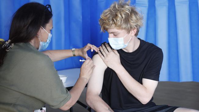 Nurse Simone Jenkinson administers a Pfizer vaccine to tradie Reuben Eadie at the Byron Bay vaccination clinic at Byron Bay Surf Life Saving Club on Friday. Picture: Liana Boss