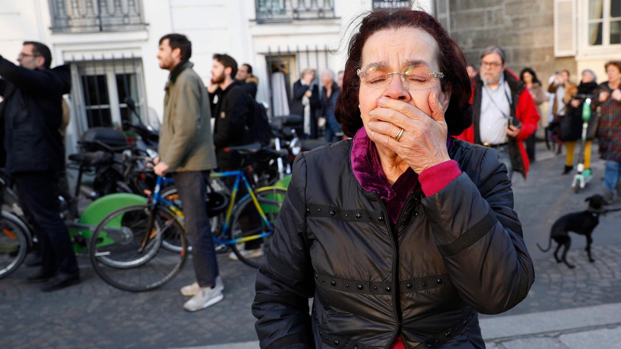 A woman reacts as she watches flames engulf the roof of the Notre Dame Cathedral in the French capital Paris. Picture: Geoffroy Van Der Hasselt / AFP 