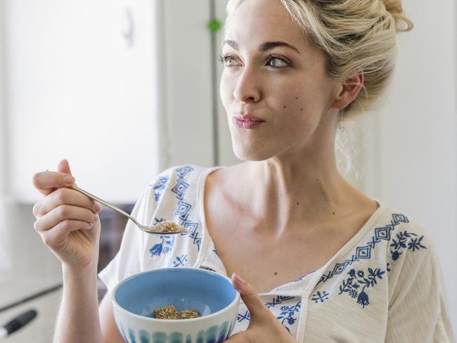 Young woman eating a bowl of cerea. Picture: Getty Images