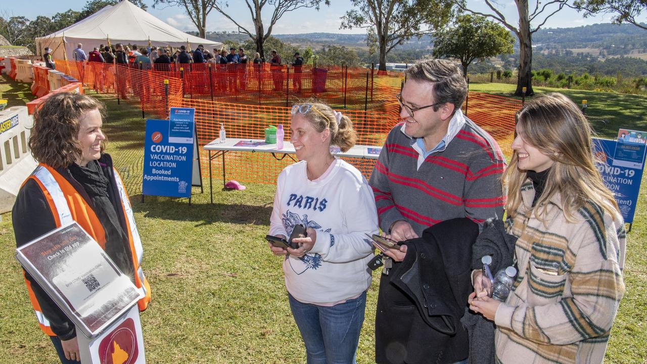 Monique Morgan, part of the Covid vaccination project team at Baillie Henderson helps Dana and Ben Gouldson and their daughter Georgia check in at the Darling Downs Health super clinic on Saturday. Picture: Nev Madsen.