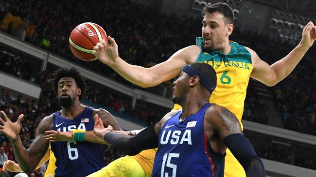 USA's forward Carmelo Anthony, centre, reaches for the ball with Australia's centre Andrew Bogut during a Men's round Group A basketball match between Australia and USA at the Rio 2016 Olympic Games. Picture: AFP