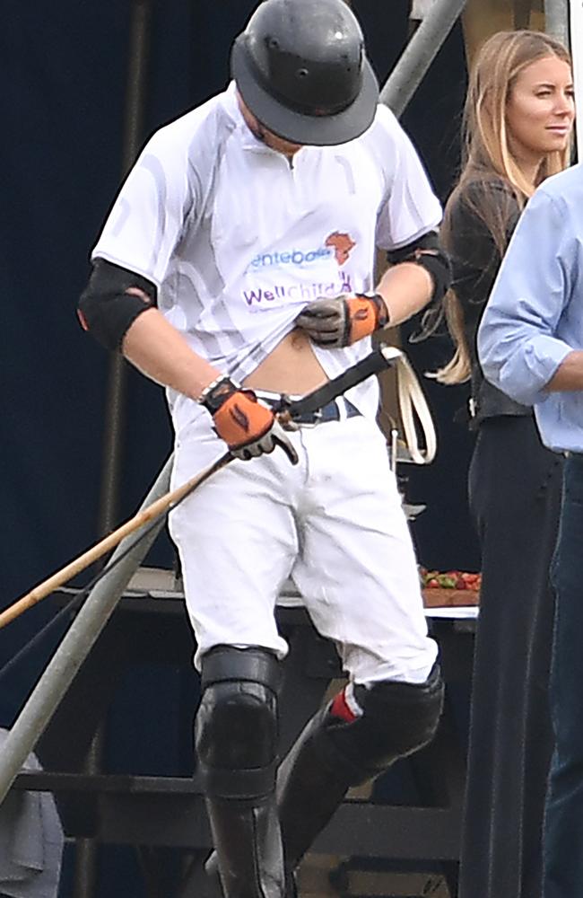 He’s in shape. Prince Harry checks on his abs while on the polo field.