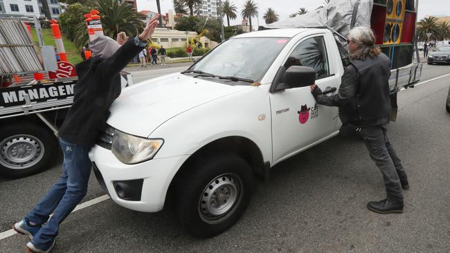 Anti-immigration demonstrators stop a vehicle with loudspeakers on the Esplanade in St Kilda. Picture: David Crosling/AAP