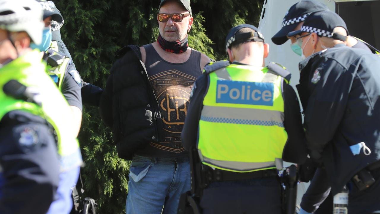 Victoria Police with a man who was cuffed but later released. Picture: Alex Coppel