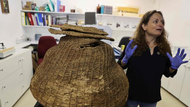 Archaeologist Naama Sukenik reveals the 10,500-year-old basket. Picture: AFP