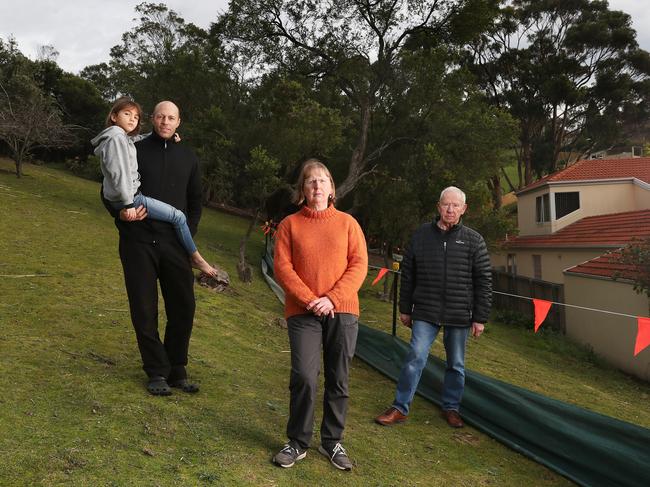 Local residents Matthew Stilwell, with daughter Maya, 8, Stephanie Cooper and Peter Voss are concerned at the Hobart City Council’s proposal to build and then remove a road to access and repair flood infrastructure. Picture: NIKKI DAVIS-JONES