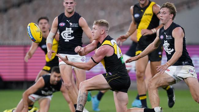 Richmond’s Josh Caddy fires off a handball during the match against Carlton. Picture: AAP Image/Michael Dodge