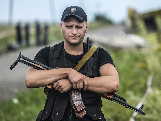 An armed pro-Russian separatist stands guard near a piece of the wreckage of the Malaysia Airlines Flight MH17. Picture: AFP Photo/ Bulent Kilic