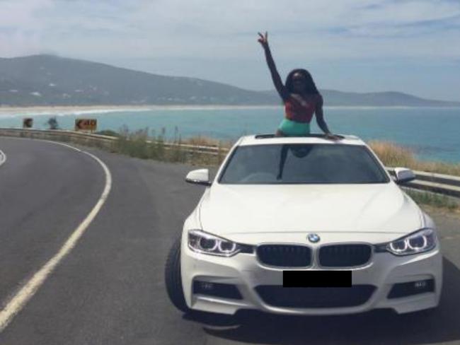 One of South Sudanese general James Hoth Mai's daughters on a stretch of Australian coastline in a BMW. The BMW is not the car subject to the seizure order.