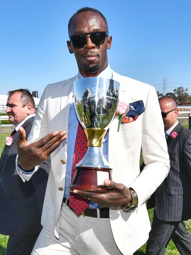 Usain Bolt showing off some silverware last year at Oaks Day. Picture: Jason Edwards