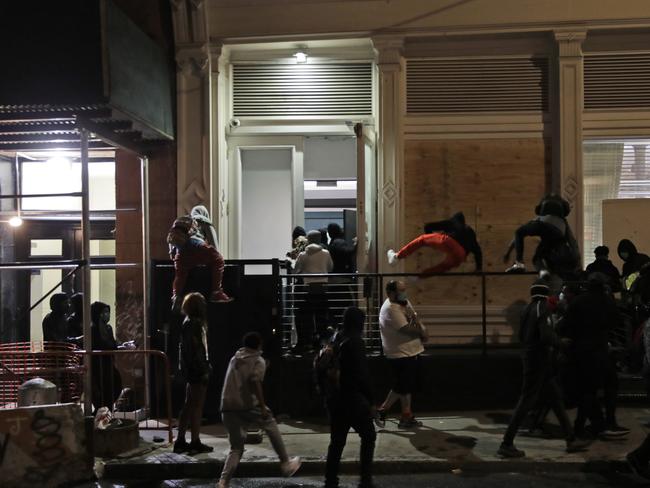 Looters rush into a Gucci store after it was broken into in New York. Picture: AP