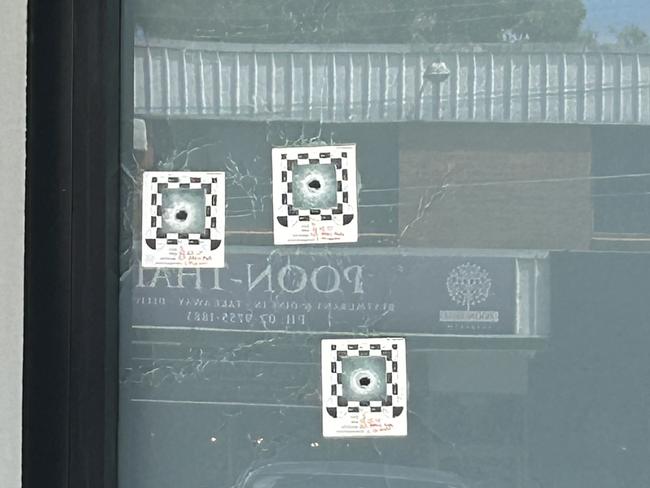 Bullet holes in the business front. Picture: Elliott Stewart