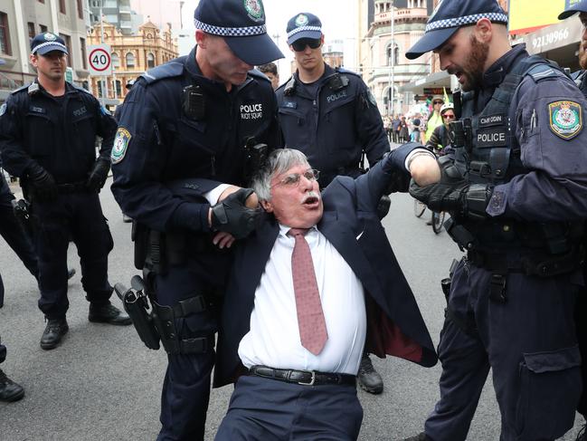 Mr Wolterding is grabbed by the arms and police apply a wrist lock to both hands. Picture: Richard Dobson