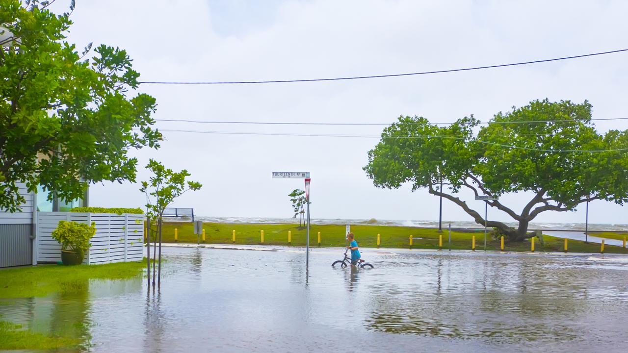 A child tries to ride his bike through the floodwaters in Brisbane's north. PHOTO CREDIT: Dianna Jean Photography.