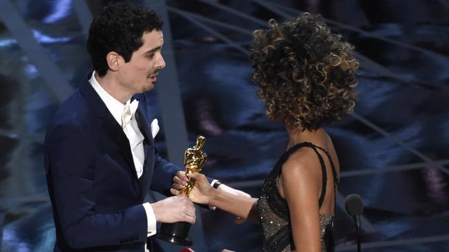 Halle Berry, right, presents Damien Chazelle with the award. Picture: AP