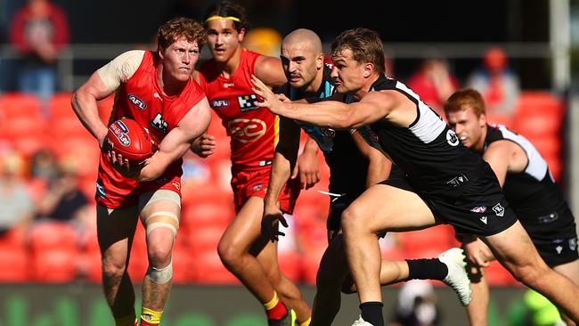 GOLD COAST, AUSTRALIA - JUNE 19: Matt Rowell of the Suns handballs during the round 14 AFL match between the Gold Coast Suns and the Port Adelaide Power at Metricon Stadium on June 19, 2021 in Gold Coast, Australia. (Photo by Chris Hyde/Getty Images)