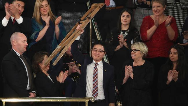 Seong-ho, a North Korean defector, raises his crutches while being honoured during rhe State of the Union address. Picture: AFP