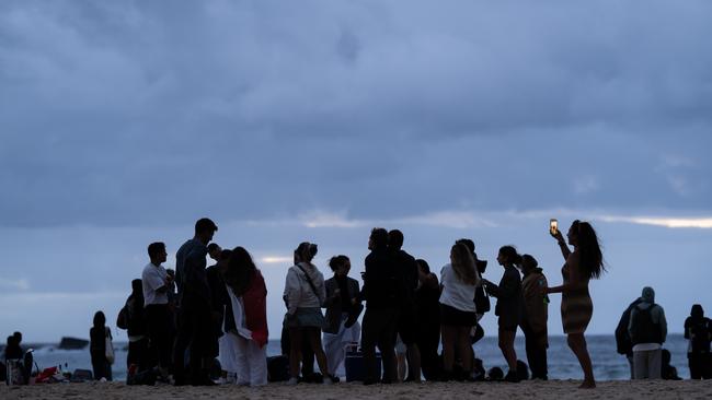 The clouds did not stop people from taking to the beach on the first day of the new year. Picture: NCA NewsWire / Mario Francisco