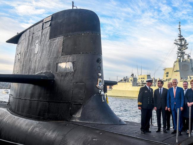 (FILES) A file photo taken on May 2, 2018 shows French President Emmanuel Macron (2/L) and Australian Prime Minister Malcolm Turnbull (C) standing on the deck of HMAS Waller, a Collins-class submarine operated by the Royal Australian Navy, at Garden Island in Sydney. - Former Australian leader Malcolm Turnbull said on September 29, 2021 his successor "deliberately deceived" France when he scrapped a multi-billion-euro submarine deal with Paris in favour of nuclear-powered US or British alternatives. (Photo by BRENDAN ESPOSITO / POOL / AFP)