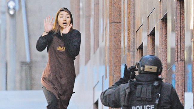 A hostage runs from the Lindt Cafe in Martin Place, Sydney, on December 15, 2014. Picture: AAP Image/Joel Carrett