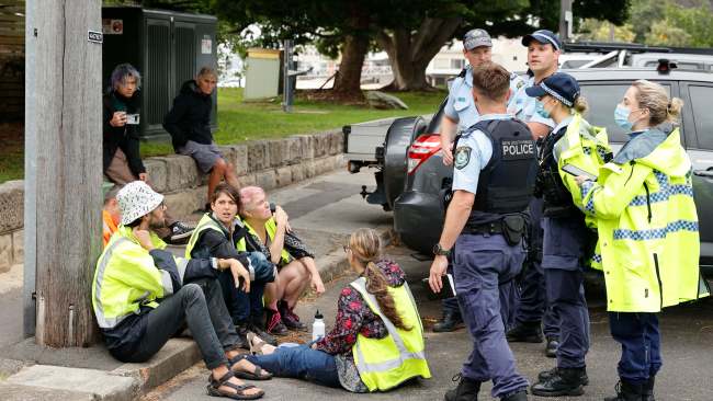 Police officers speaking with the handful of protesters before they were free to leave the scene. Picture: Tim Hunter