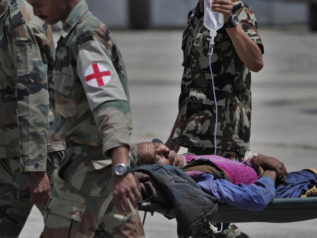 A Nepalese man injured in Tuesday’s earthquake brought from Charikot, Dolakha District is carried on a stretcher at the Tribhuvan International Airport in Kathmandu, Nepal, Wednesday, May 13, 2015. Thousands of fear-stricken people spent the night out in the open as a new earthquake killed dozens of people and spread more misery in Nepal, which is still struggling to recover from a devastating quake nearly three weeks ago. (AP Photo/Niranjan Shrestha)