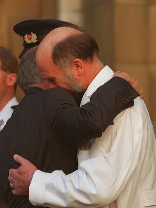 PM John Howard embraces Dr Bryan Walpole when he broke down after the memorial service.