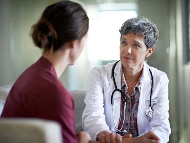 Shot of a compassionate doctor comforting a young woman in a hospital waiting room; fear health scare generic