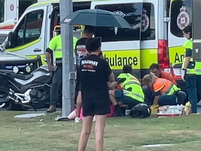 A man is being treated by paramedics following a car and motorbike crash on the Gold Coast Highway in Southport. Photo: Charlton Hart