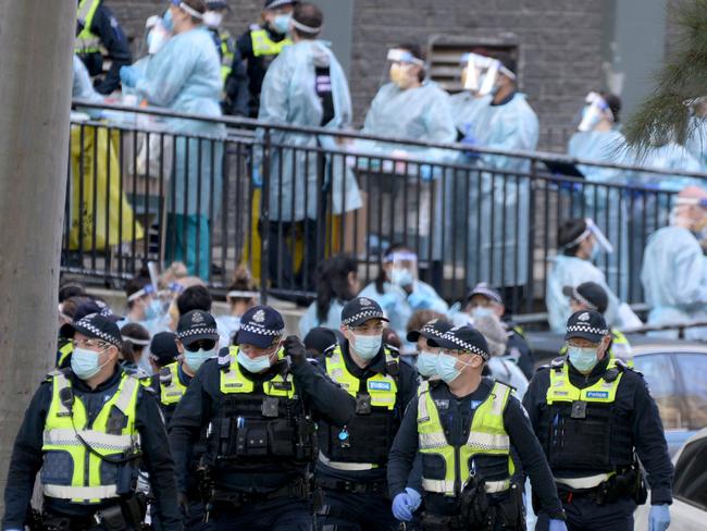 Police and healthcare workers outside the North Melbourne public housing estate. Picture: NCA NewsWire / Andrew Henshaw