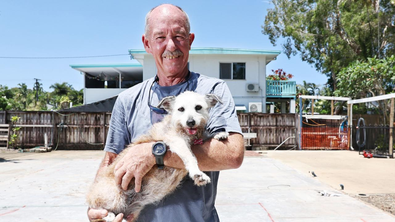 After having their Holloways Beach house badly damaged in last year's flood, Chris Tress and his wife have made the decision to demolish the existing structure and build a new, smaller kit home on the existing slab. The couple hope to have their new home completed by June. Chris Tress stands on the site of his old home with his dog Peg. Picture: Brendan Radke