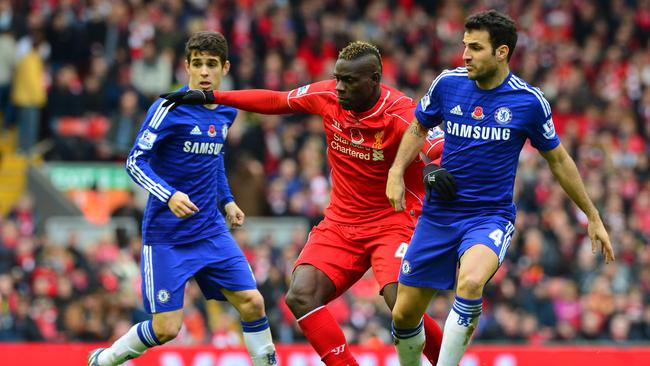 Cesc Fabregas (R) vies with Liverpool's Italian striker Mario Balotelli.