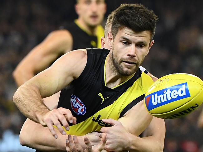 MELBOURNE, AUSTRALIA - JUNE 07: Trent Cotchin of the Tigers handballs whilst being tackled by Mitch Duncan of the Cats during the round 12 AFL match between the Richmond Tigers and the Geelong Cats at Melbourne Cricket Ground on June 07, 2019 in Melbourne, Australia. (Photo by Quinn Rooney/Getty Images)